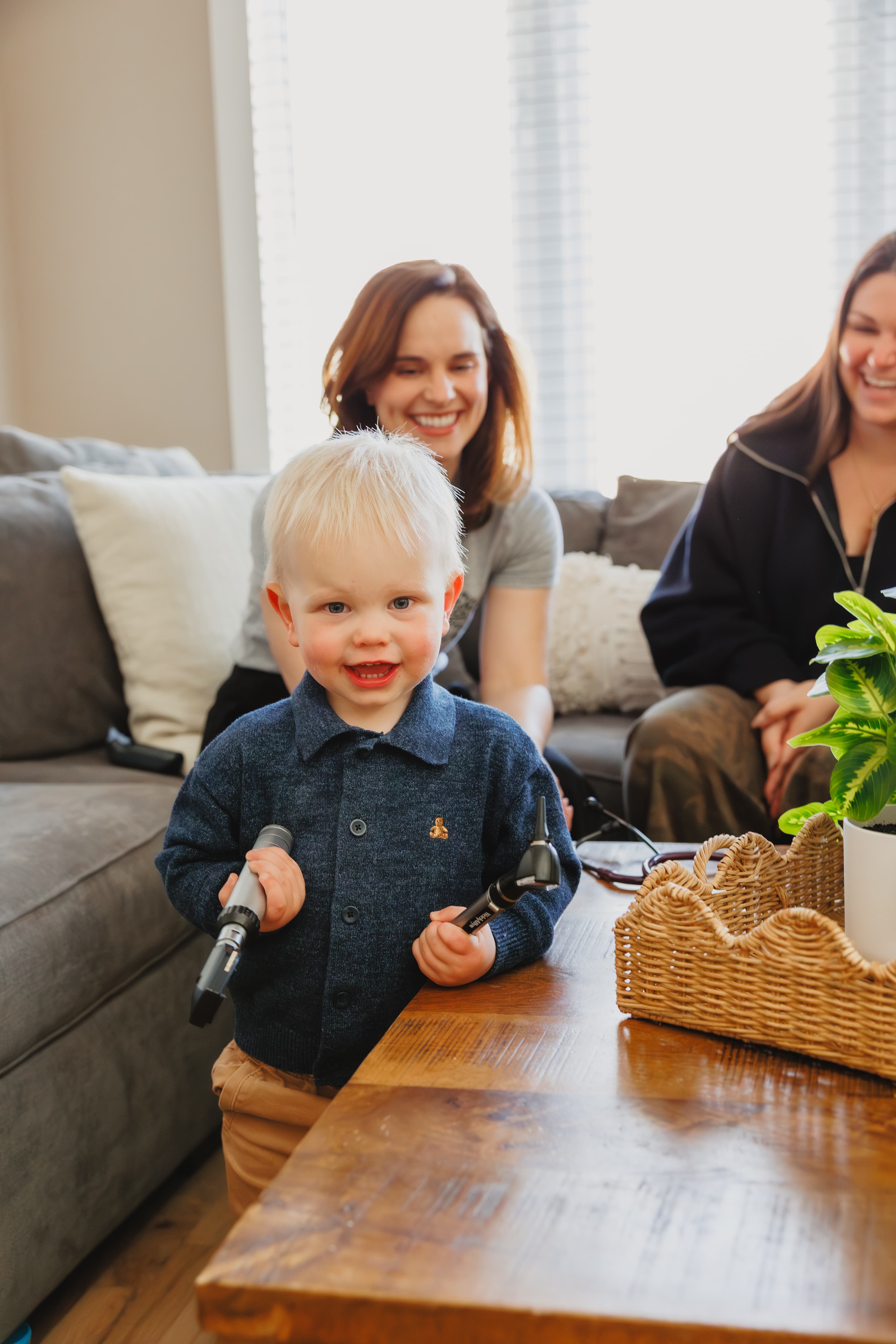 Pediatrician examining a baby during an in-home visit with a parent
